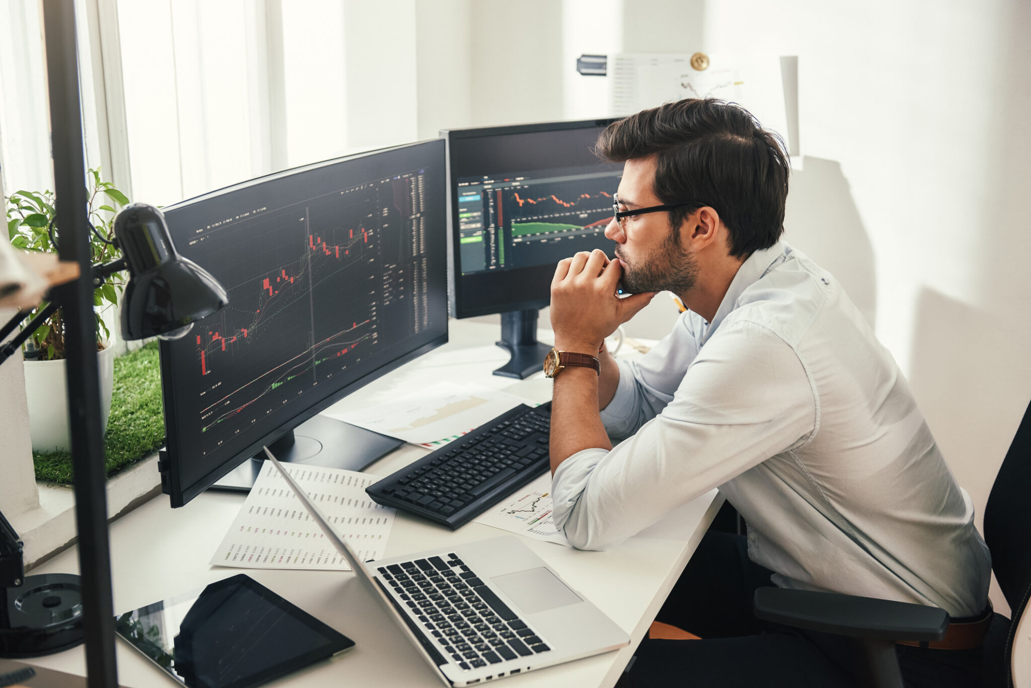 person sitting at a desk looking at two monitors scaled