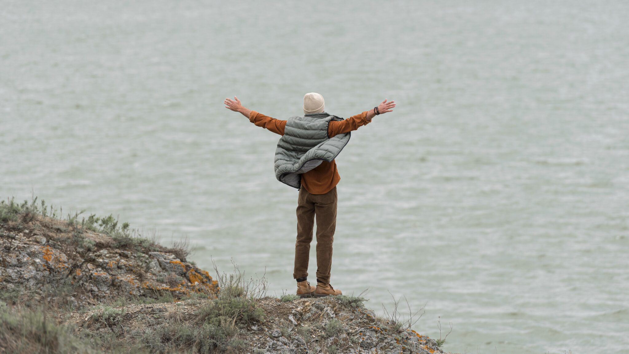 long shot man with hands air facing water scaled